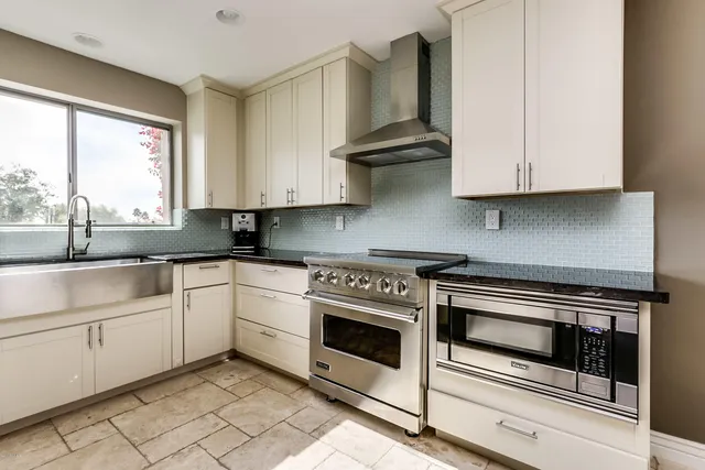 a kitchen with granite countertop white cabinets and white appliances
