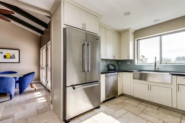 a kitchen with stainless steel appliances granite countertop a refrigerator and a sink