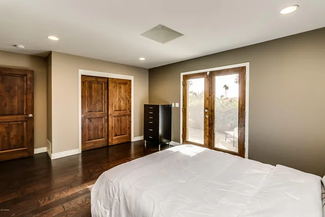 a bedroom with a bed and wooden floor