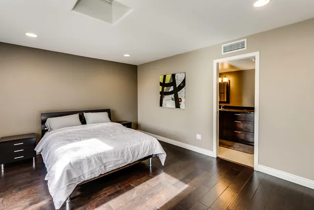 a large bed sitting in a bedroom next to a bathroom