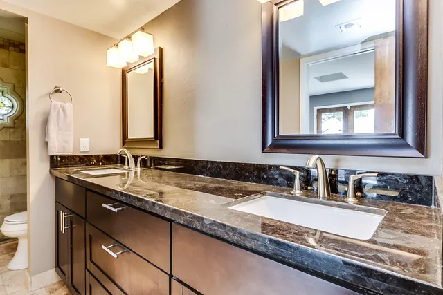 a bathroom with a granite countertop sink and a mirror