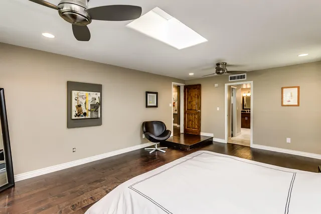 a room with gym equipment and wooden floor