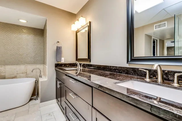 a bathroom with a double vanity sink and a bathtub