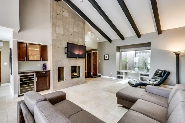 a living room with furniture a flat screen tv and a fireplace