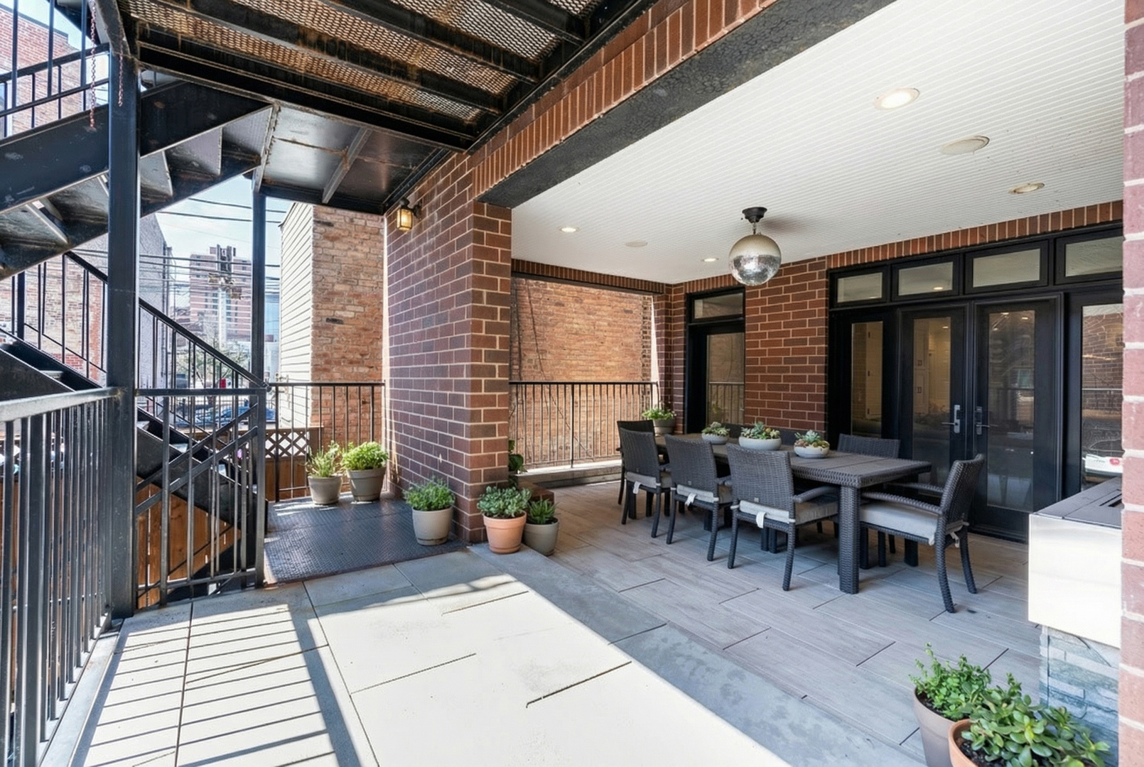 729 West Barry Avenue, Unit 1 Chicago, IL 60657 - Photo 28 of 34 a view of a patio with table and chairs potted plants with wooden floor and fence