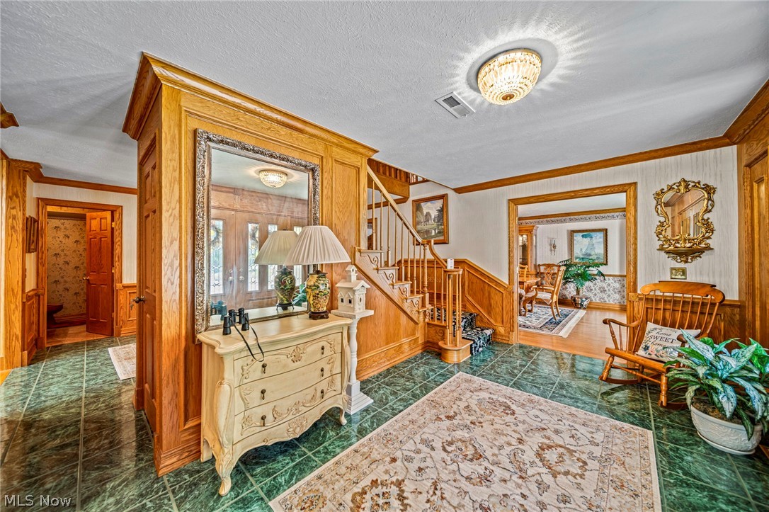 8801 Bunker Road Orwell, OH 44076 - Photo 8 of 50 Living area featuring stairway, wainscoting, crown molding, and a textured ceiling