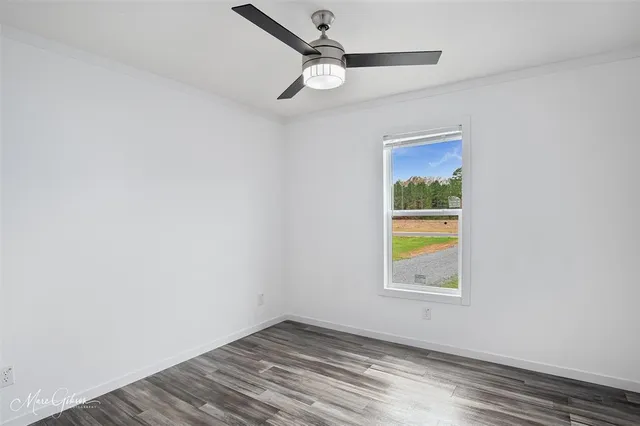 an empty room with a window and ceiling fan