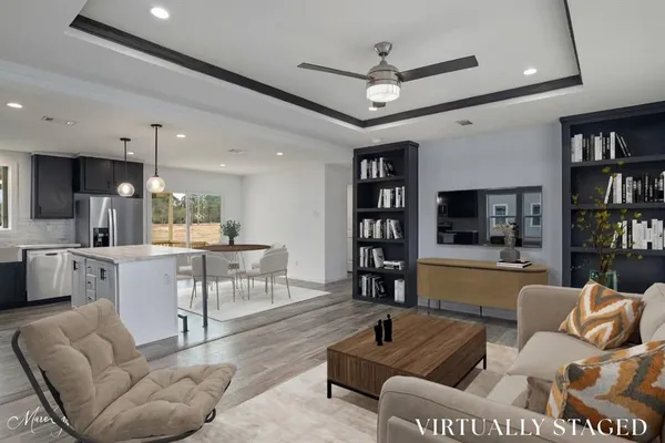 a living room with furniture kitchen view and a large window