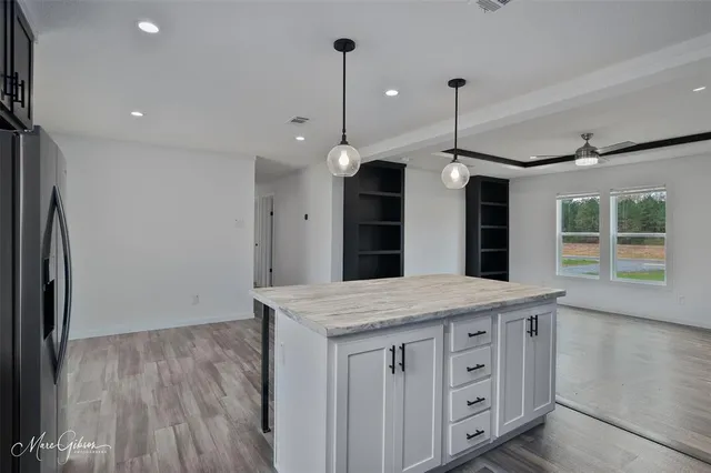 a kitchen with a refrigerator a sink and wooden floor