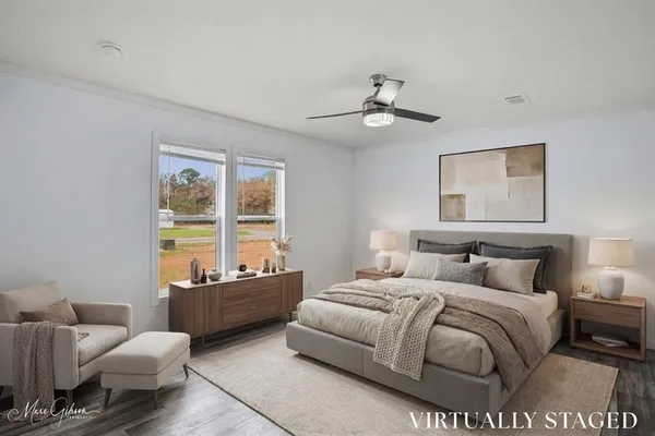 a bedroom with a bed couches and window