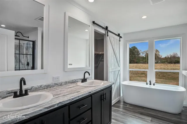 a bathroom with a granite countertop sink and a large mirror