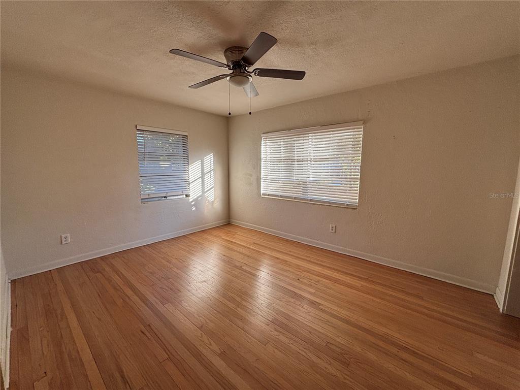1102 Sunset Point Road, Unit 6 Clearwater, FL 33755 - Photo 13 of 31 a view of an empty room with wooden floor and a window