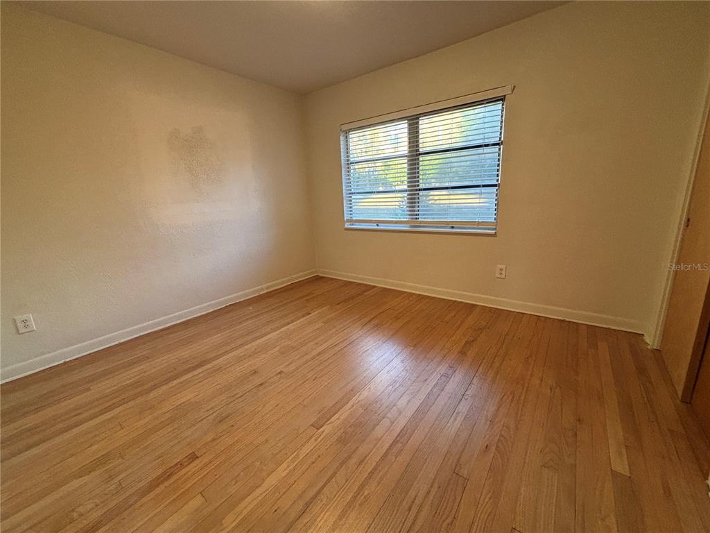 1102 Sunset Point Road, Unit 6 Clearwater, FL 33755 - Photo 16 of 31 a view of an empty room with wooden floor and a window