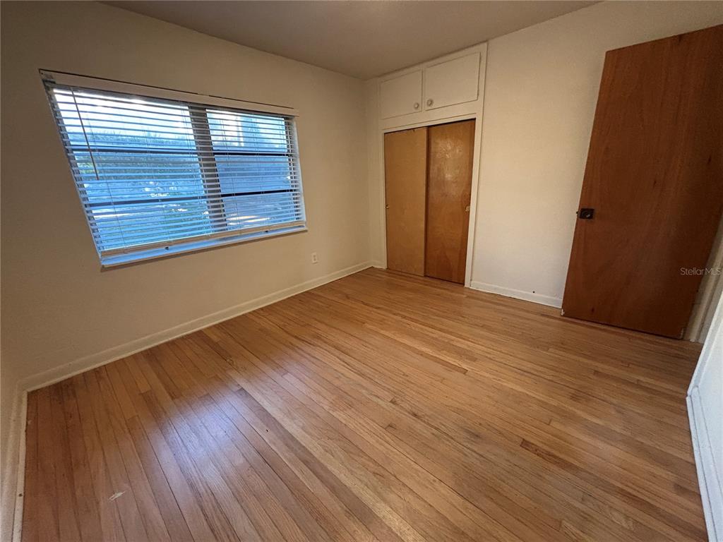 1102 Sunset Point Road, Unit 6 Clearwater, FL 33755 - Photo 17 of 31 a view of an empty room with wooden floor and a window