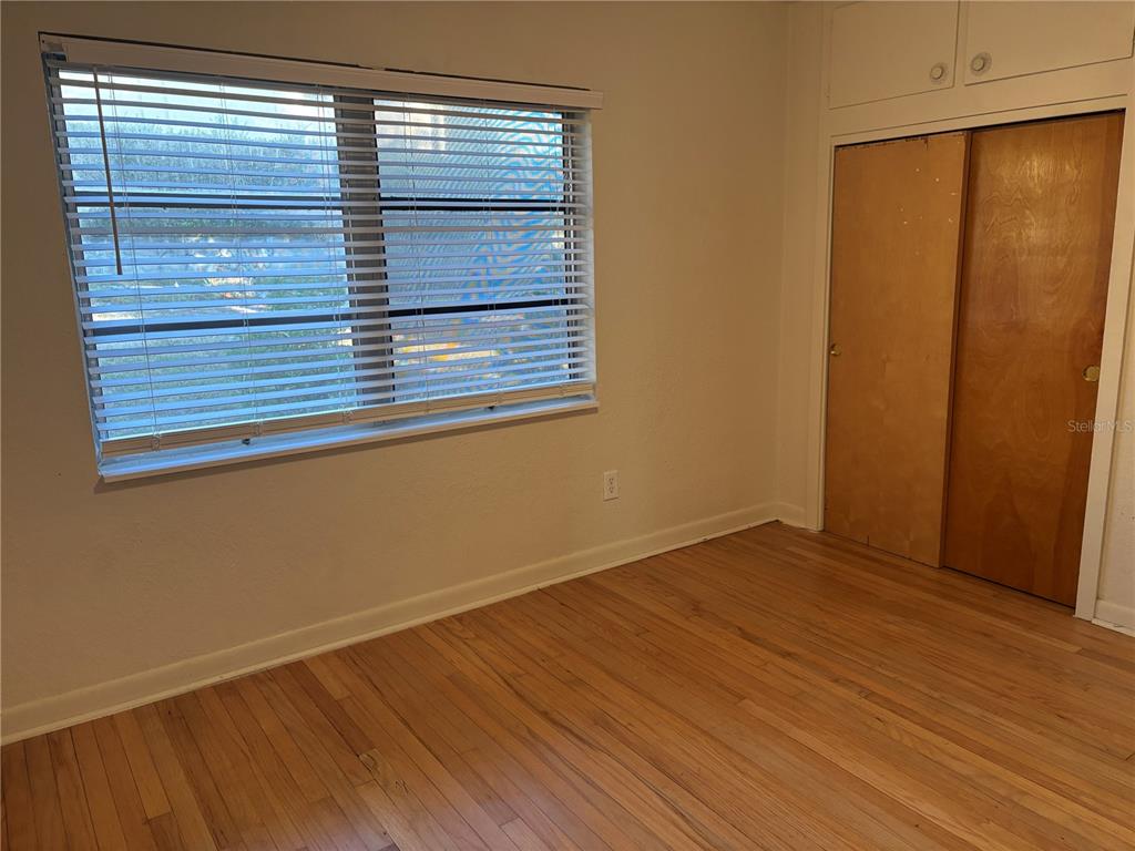 1102 Sunset Point Road, Unit 6 Clearwater, FL 33755 - Photo 18 of 31 an empty room with wooden floor and windows