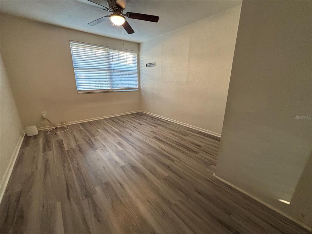 1102 Sunset Point Road, Unit 6 Clearwater, FL 33755 - Photo 23 of 31 wooden floor in an empty room with a window