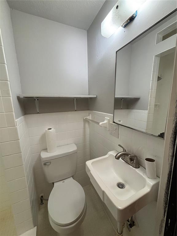 1102 Sunset Point Road, Unit 6 Clearwater, FL 33755 - Photo 25 of 31 a bathroom with a toilet sink and mirror