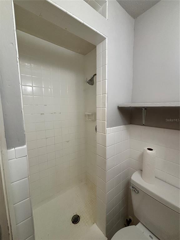 1102 Sunset Point Road, Unit 6 Clearwater, FL 33755 - Photo 26 of 31 a bathroom with a shower and toilet