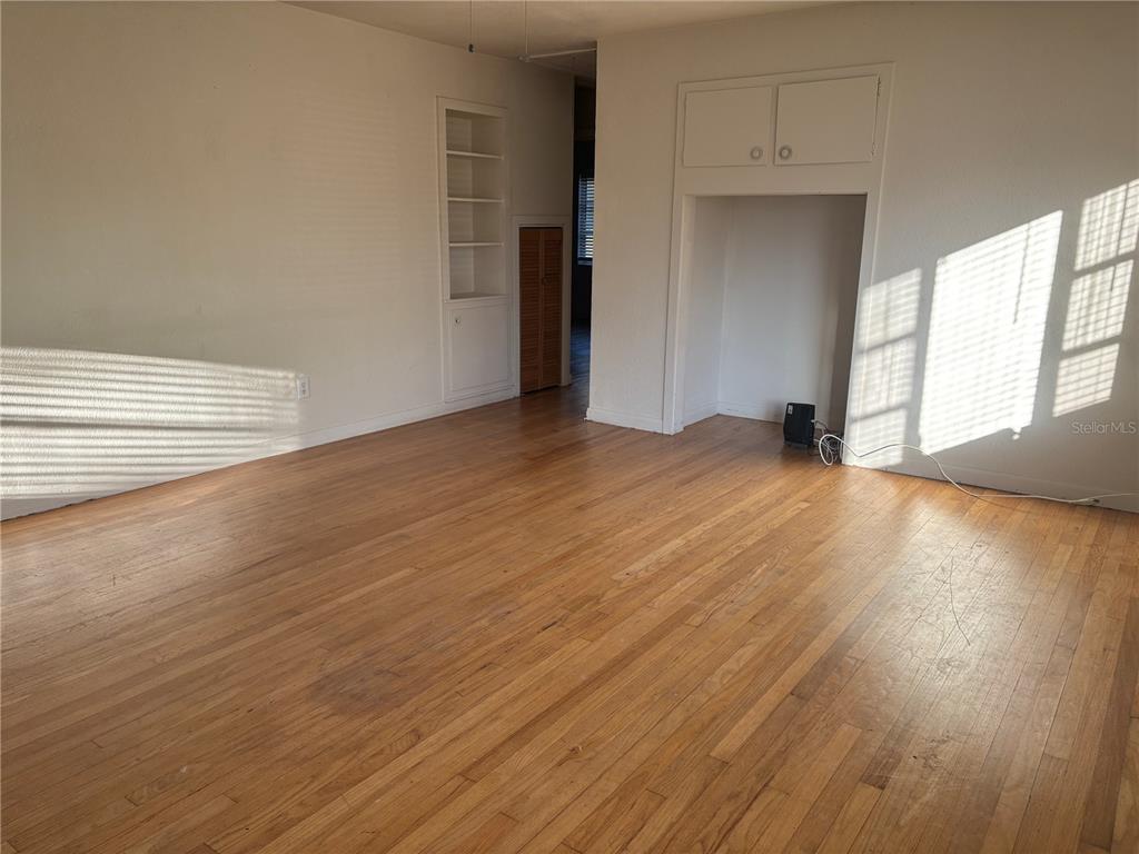 1102 Sunset Point Road, Unit 6 Clearwater, FL 33755 - Photo 4 of 31 a view of an empty room with wooden floor and a window