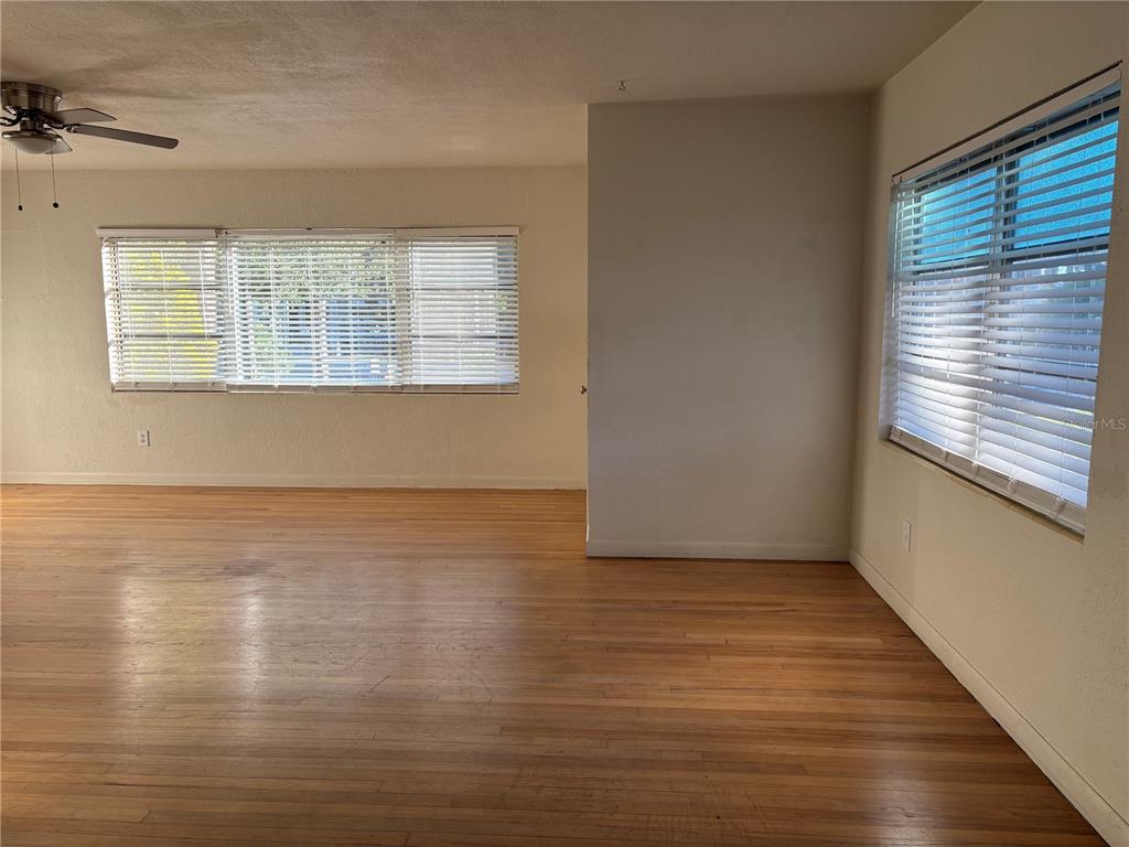 1102 Sunset Point Road, Unit 6 Clearwater, FL 33755 - Photo 5 of 31 a view of an empty room with wooden floor and a window