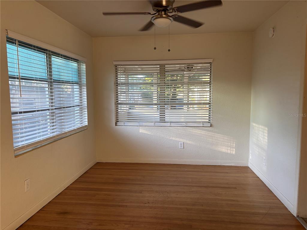 1102 Sunset Point Road, Unit 6 Clearwater, FL 33755 - Photo 6 of 31 a view of an empty room with wooden floor and a window