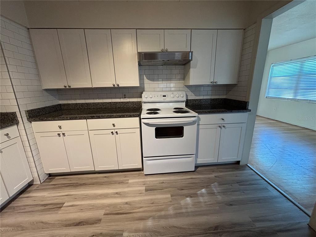 1102 Sunset Point Road, Unit 6 Clearwater, FL 33755 - Photo 9 of 31 a kitchen with white cabinets and white appliances