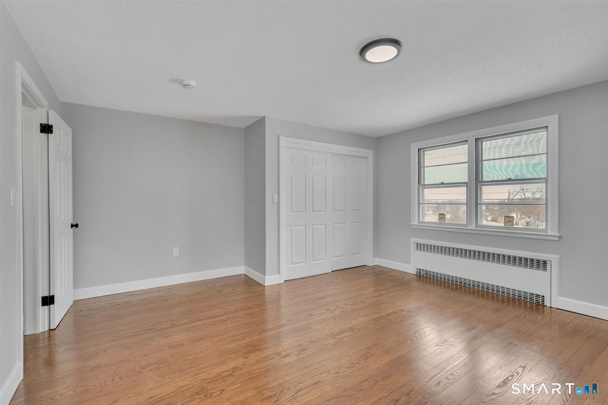 909 Randolph Road Middletown, CT 06457 - Photo 11 of 24 an empty room with wooden floor and windows