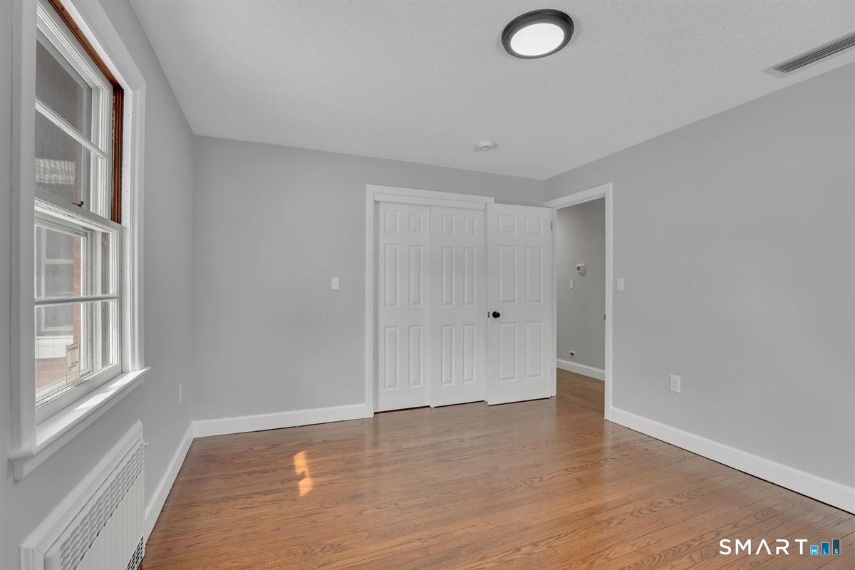 909 Randolph Road Middletown, CT 06457 - Photo 13 of 24 a view of empty room with window and wooden floor