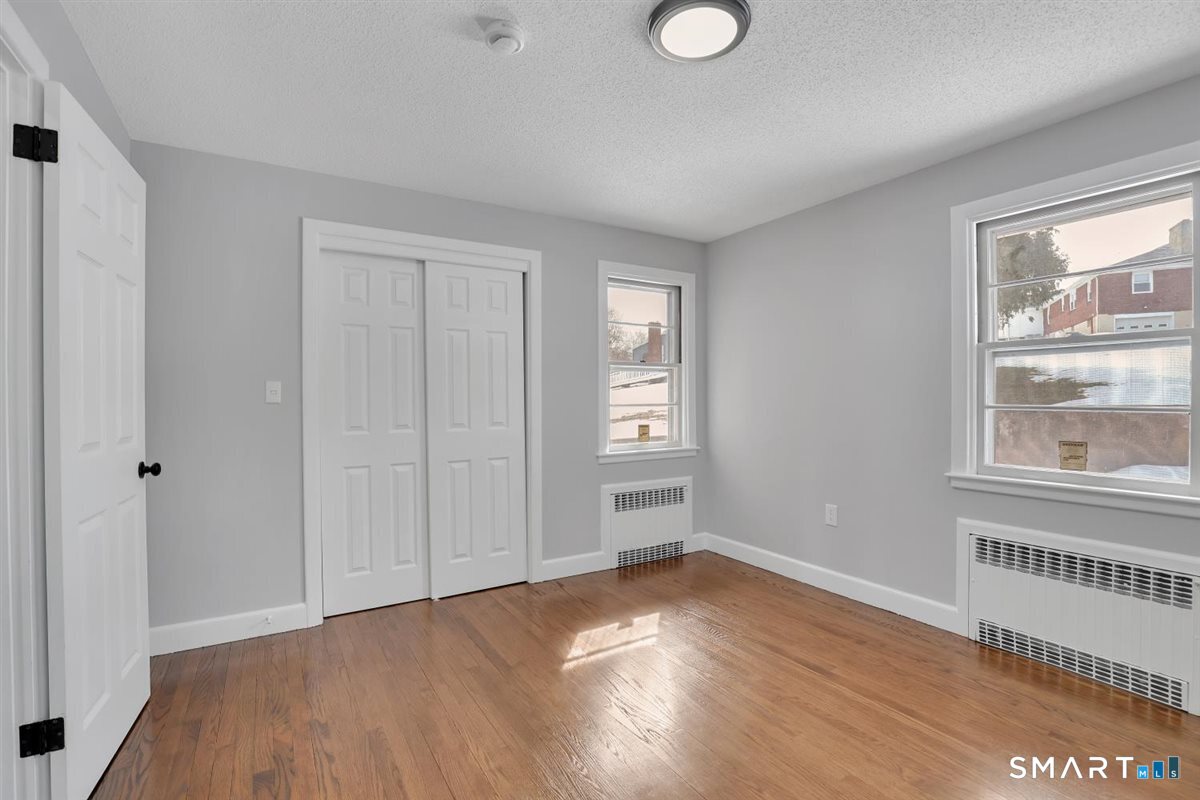 909 Randolph Road Middletown, CT 06457 - Photo 14 of 24 a view of an empty room with wooden floor and a window