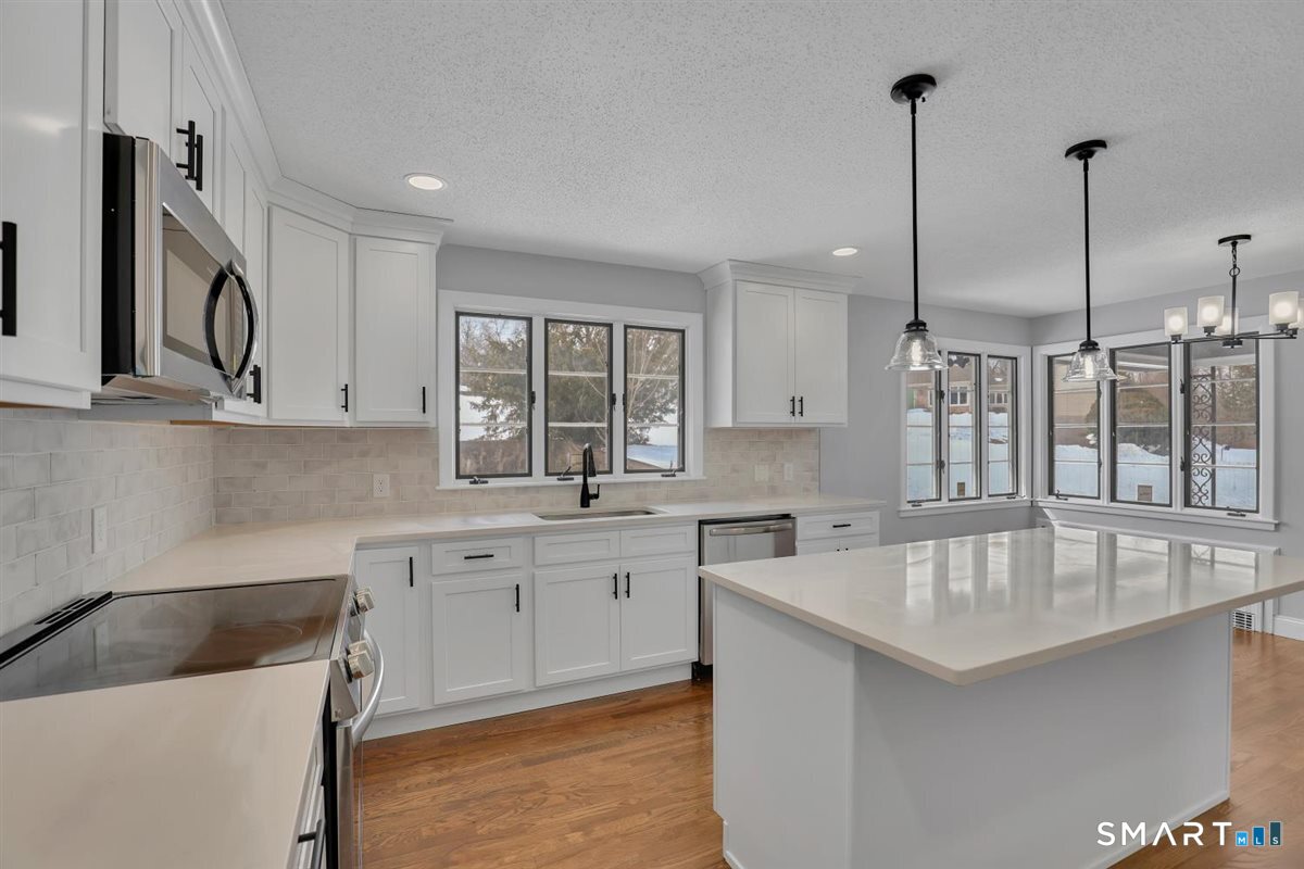 909 Randolph Road Middletown, CT 06457 - Photo 4 of 24 a kitchen with stainless steel appliances granite countertop a sink a stove and a wooden floors