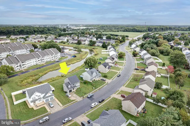 a view of a house with a big yard and large trees
