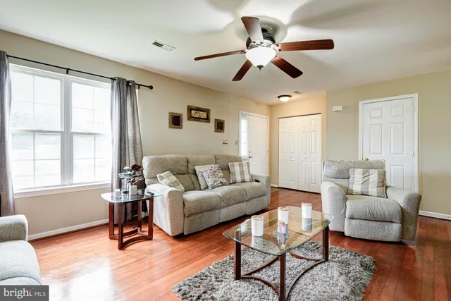 a living room with furniture a ceiling fan and a window