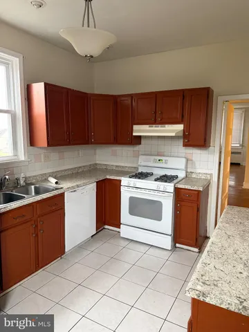 a bathroom with a granite countertop sink and a window