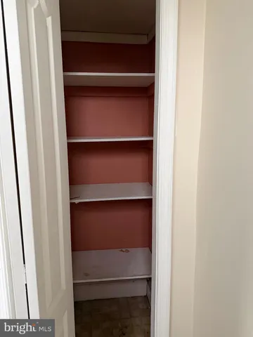 a view of an empty room with stairs and utility room