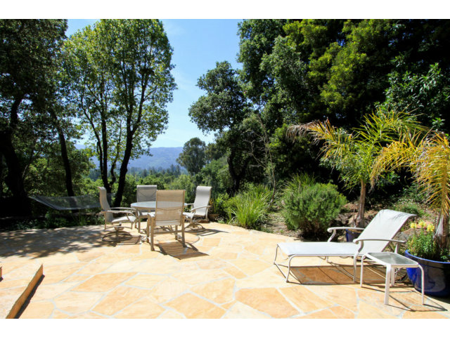 188 Alta Mesa Road Woodside, CA 94062 - Photo 22 of 25 a view of a patio with a table and chairs under an umbrella