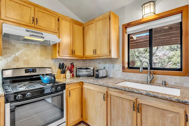 a kitchen with stainless steel appliances granite countertop a refrigerator stove oven table and chairs