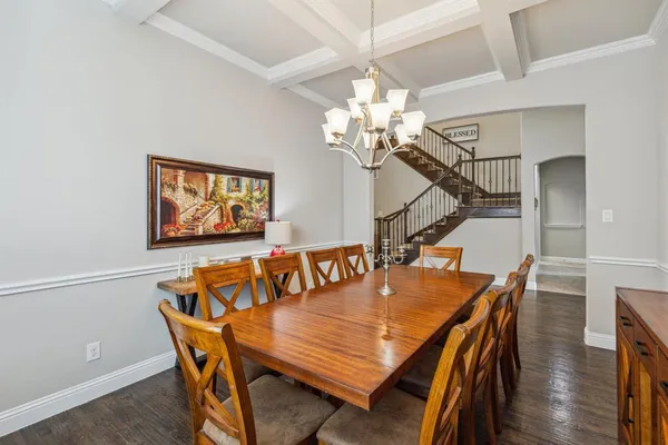a dining room with furniture a chandelier and wooden floor