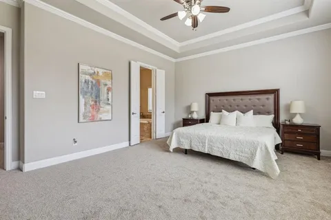 a spacious bedroom with a bed and a chandelier