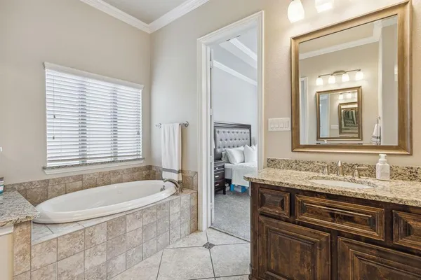 a bathroom with a granite countertop tub sink and mirror
