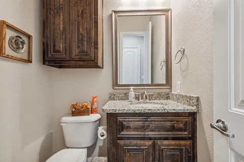 a bathroom with a toilet sink and mirror
