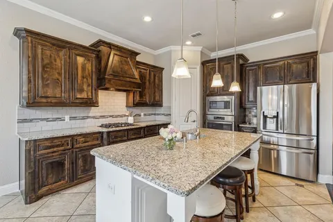 a kitchen with kitchen island granite countertop stainless steel appliances a sink stove and refrigerator