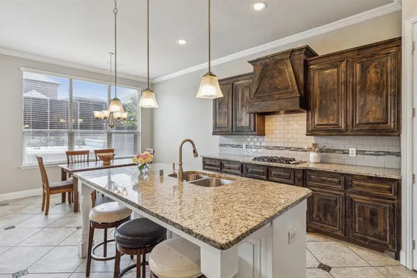a kitchen with center island a counter space a sink appliances and cabinets
