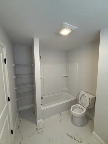 a bathroom with a toilet and a shower
