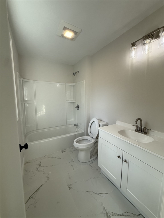 63 North Street, Unit A Worcester, MA 01605 - Photo 12 of 19 a bathroom with a granite countertop sink a toilet and a shower