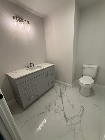 a bathroom with a sink mirror vanity and toilet