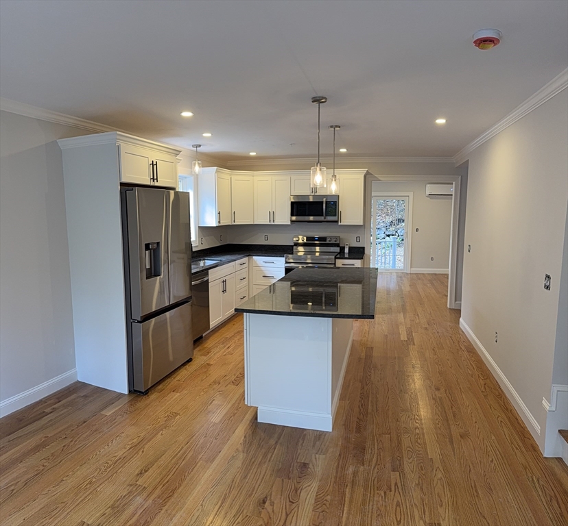 63 North Street, Unit A Worcester, MA 01605 - Photo 19 of 19 a kitchen with stainless steel appliances a refrigerator sink and wooden floor