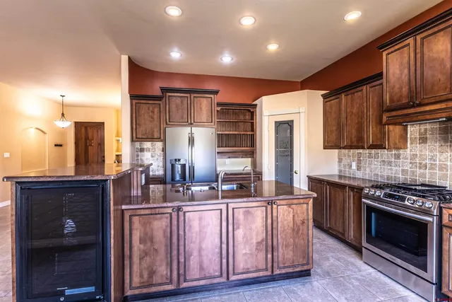 a kitchen with granite countertop a stove cabinets and refrigerator