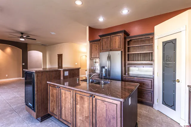 a kitchen with stainless steel appliances granite countertop a sink refrigerator and cabinets