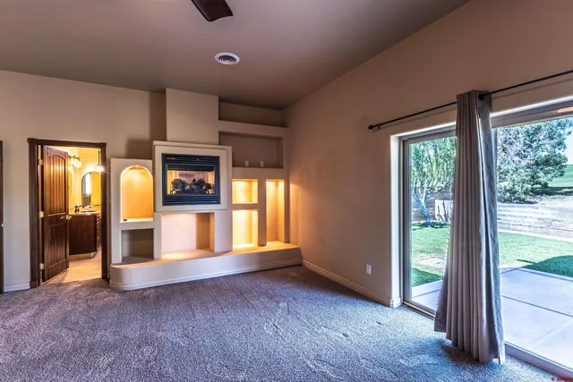 a view of an empty room with glass door and balcony