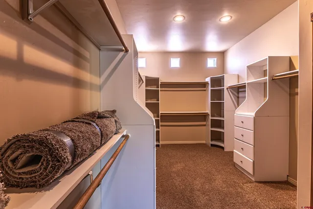 a view of walk in closet with clothes and shoes
